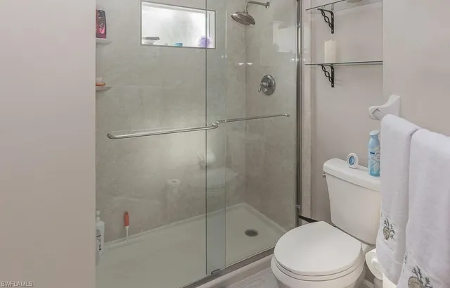 a white toilet sitting next to a bath tub and shower