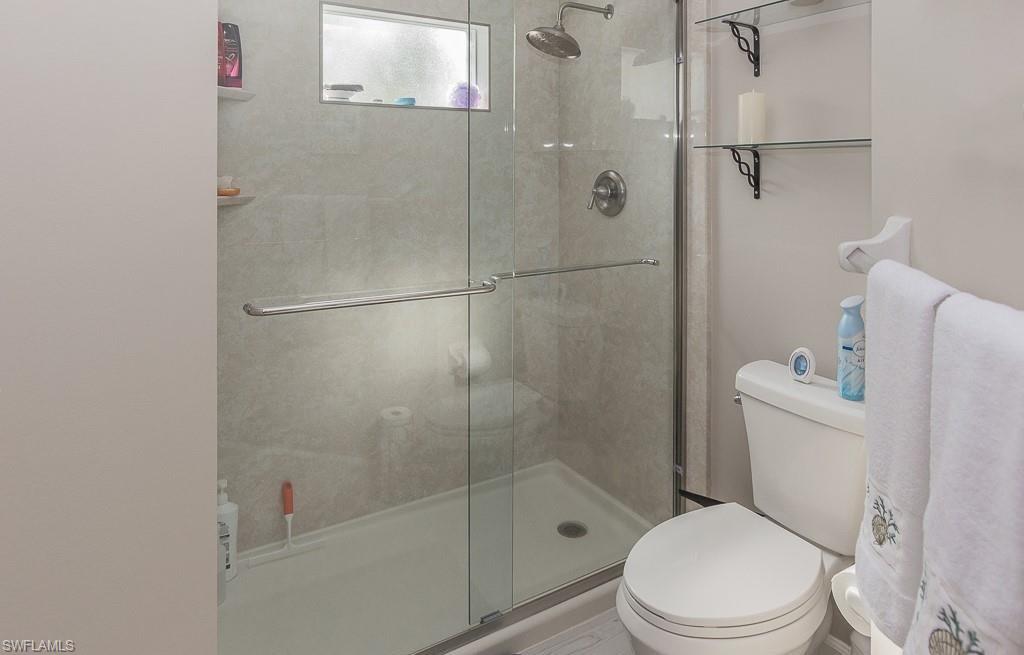 960 Partridge Circle, Unit 1202 Naples, FL 34104 - Photo 9 of 23 a white toilet sitting next to a bath tub and shower