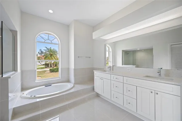 a spacious bathroom with 2 sink tub and a mirror