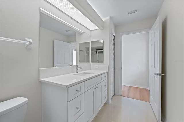 a bathroom with a sink a toilet a mirror and vanity