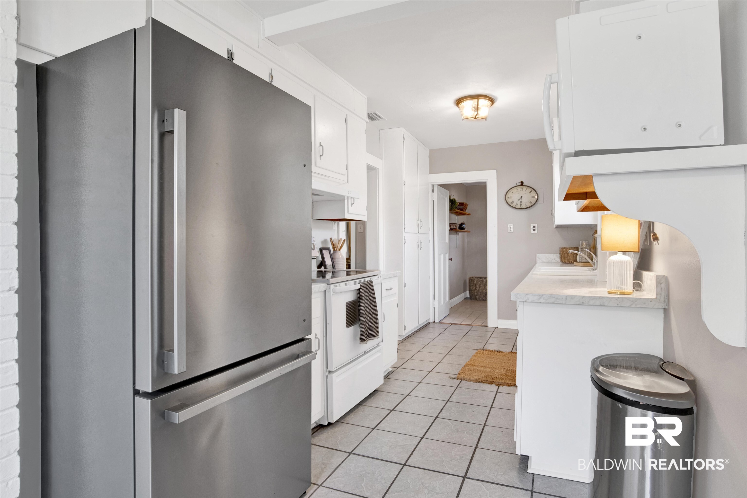 160 Emogene Place Mobile, AL 36606 - Photo 10 of 32 Kitchen with freestanding refrigerator, light countertops, white cabinets, light tile patterned floors, and white electric range oven