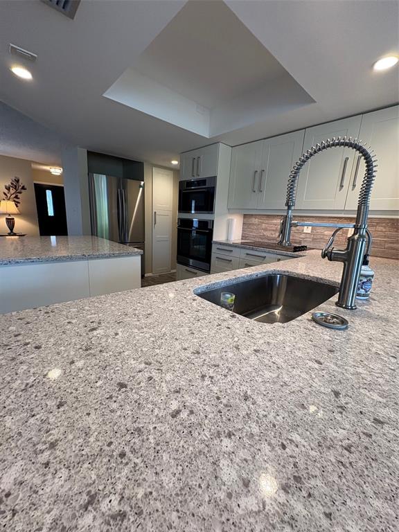 947 Shasta Road Venice, FL 34293 - Photo 21 of 52 a kitchen with kitchen island a sink and a stove with wooden floors