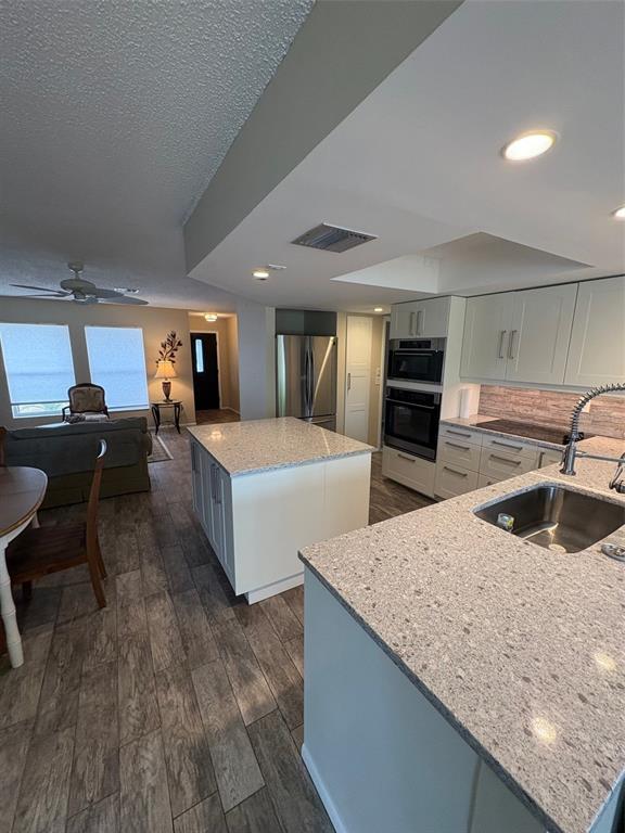 947 Shasta Road Venice, FL 34293 - Photo 25 of 52 a large kitchen with granite countertop a sink and a refrigerator