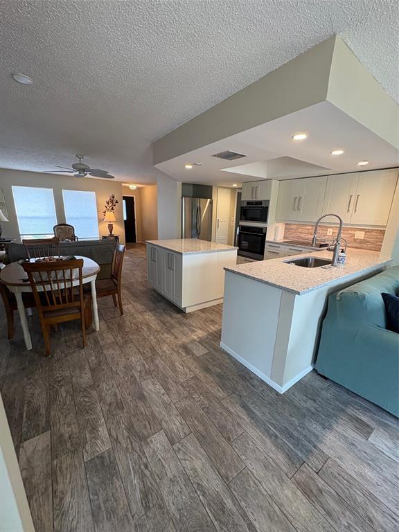 947 Shasta Road Venice, FL 34293 - Photo 40 of 52 a kitchen with stainless steel appliances granite countertop a stove and a wooden floors