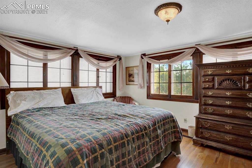 1225 Alexander Road Colorado Springs, CO 80909 - Photo 14 of 26 a bedroom with a bed and a dresser