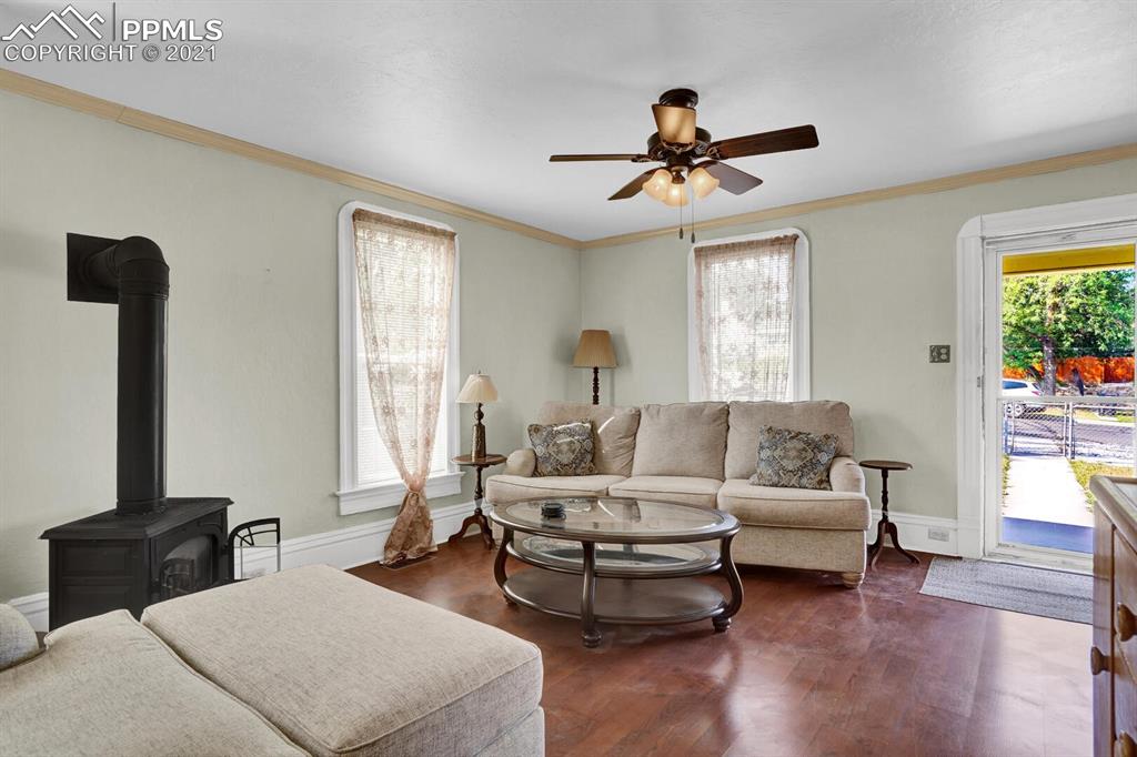 1225 Alexander Road Colorado Springs, CO 80909 - Photo 5 of 26 a living room with couches and a flat screen tv with wooden floor