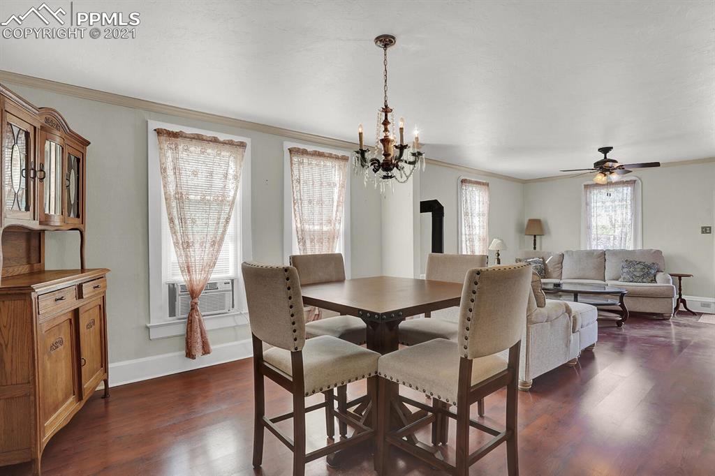 1225 Alexander Road Colorado Springs, CO 80909 - Photo 7 of 26 a view of a dining room with furniture window and wooden floor