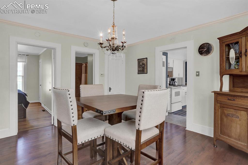 1225 Alexander Road Colorado Springs, CO 80909 - Photo 8 of 26 a view of a dining room with furniture and wooden floor
