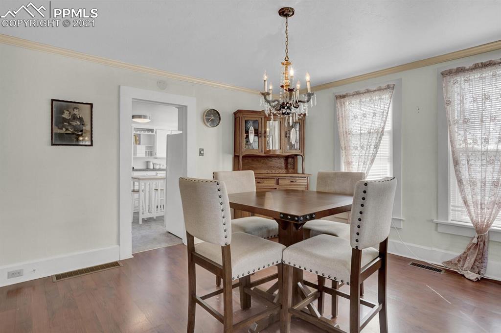 1225 Alexander Road Colorado Springs, CO 80909 - Photo 9 of 26 a view of a dining room with furniture window and wooden floor