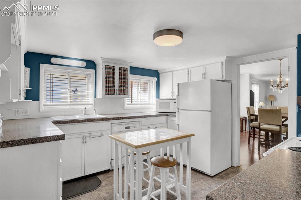 1225 Alexander Road Colorado Springs, CO 80909 - Photo 10 of 26 a kitchen with a sink stove and refrigerator