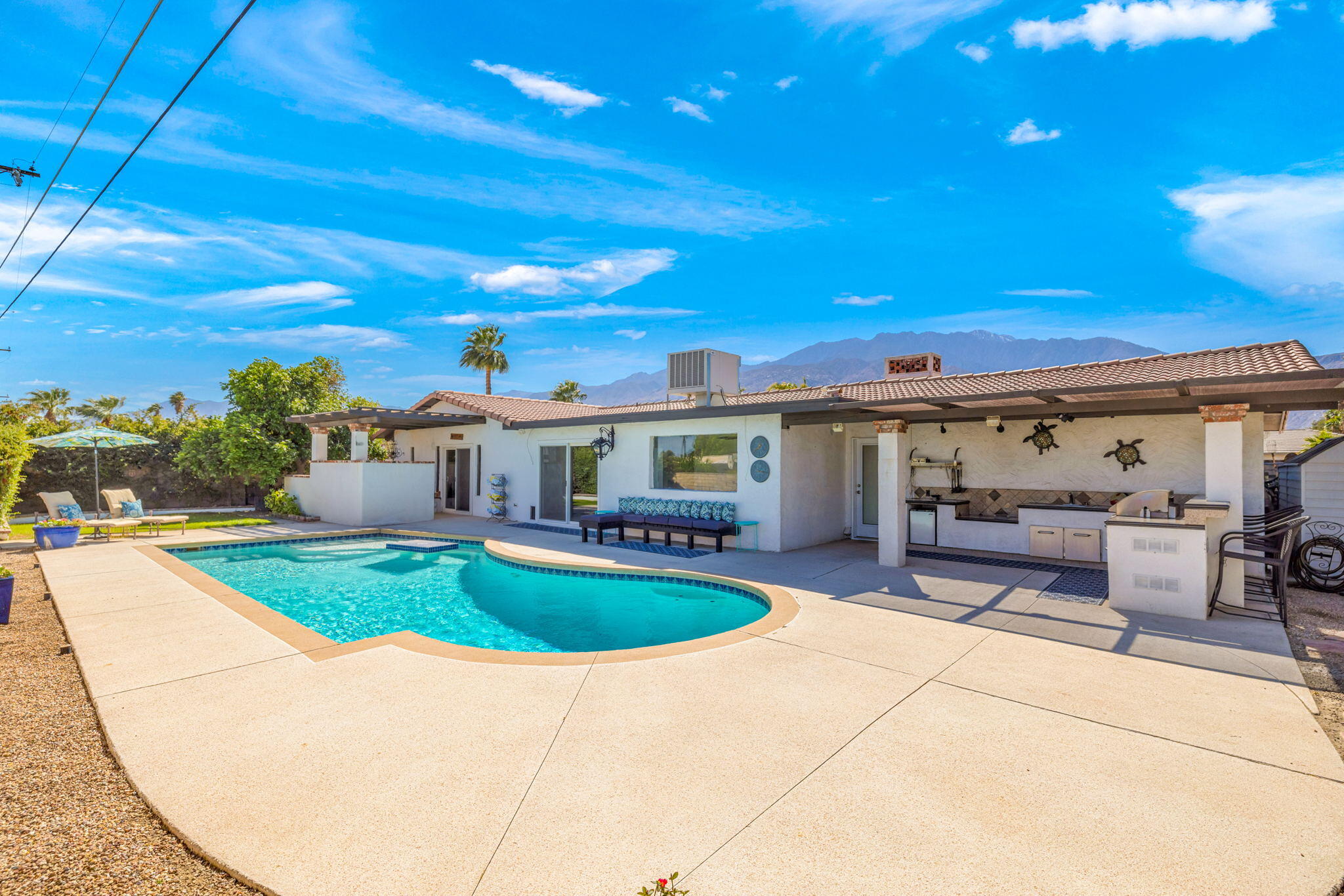 a view of a house with swimming pool and sitting area