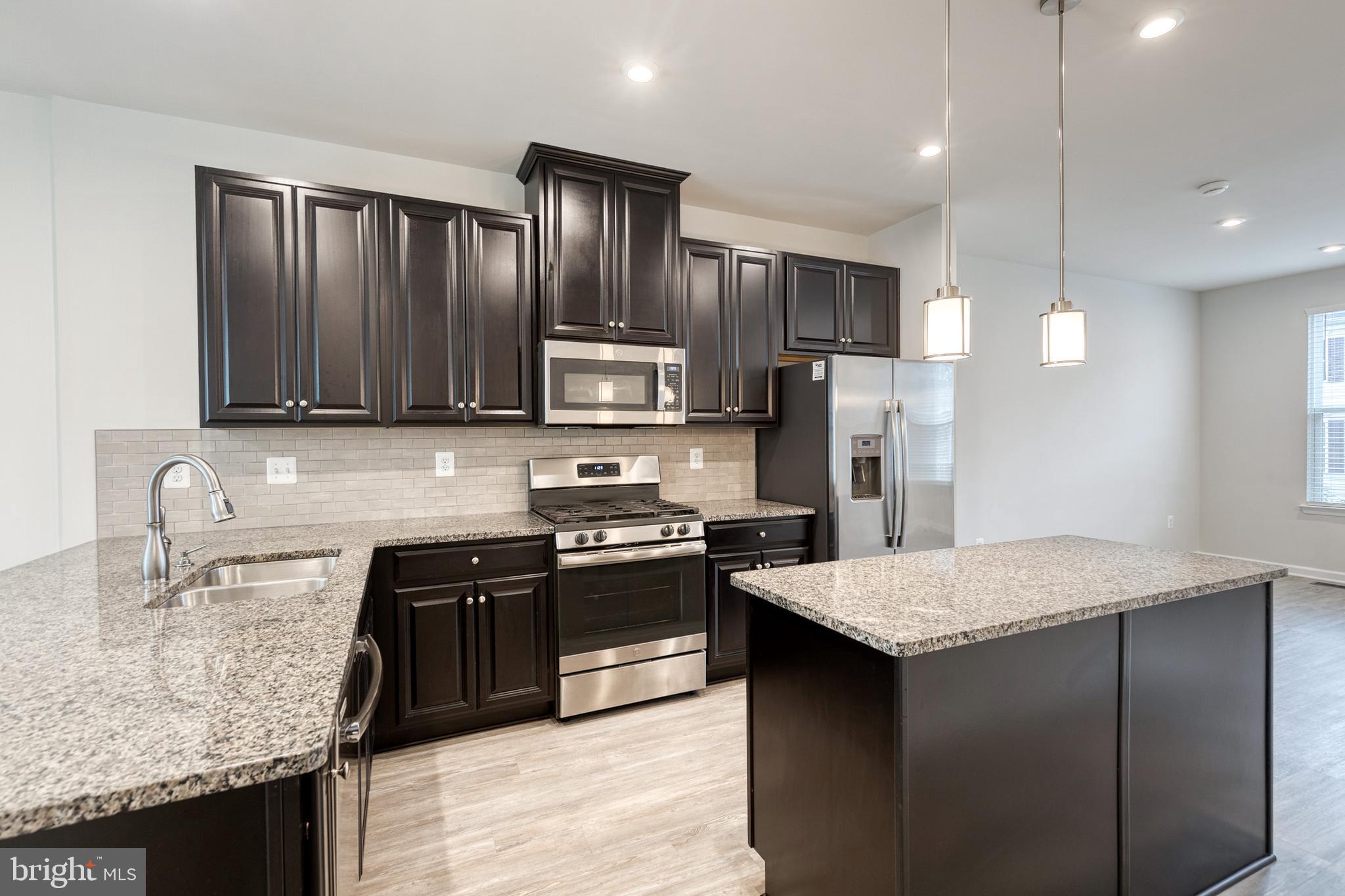 1438 Strahorn Road Hanover, MD 21076 - Photo 5 of 19 a kitchen with stainless steel appliances granite countertop a sink stove refrigerator and cabinets