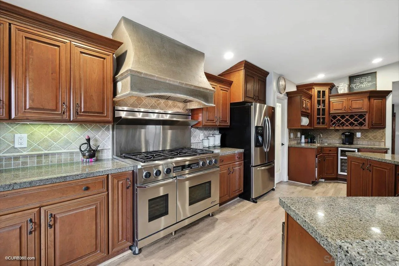 9541 Mandeville Road Santee, CA 92071 - Photo 11 of 32 a kitchen with stainless steel appliances granite countertop a stove refrigerator and a sink