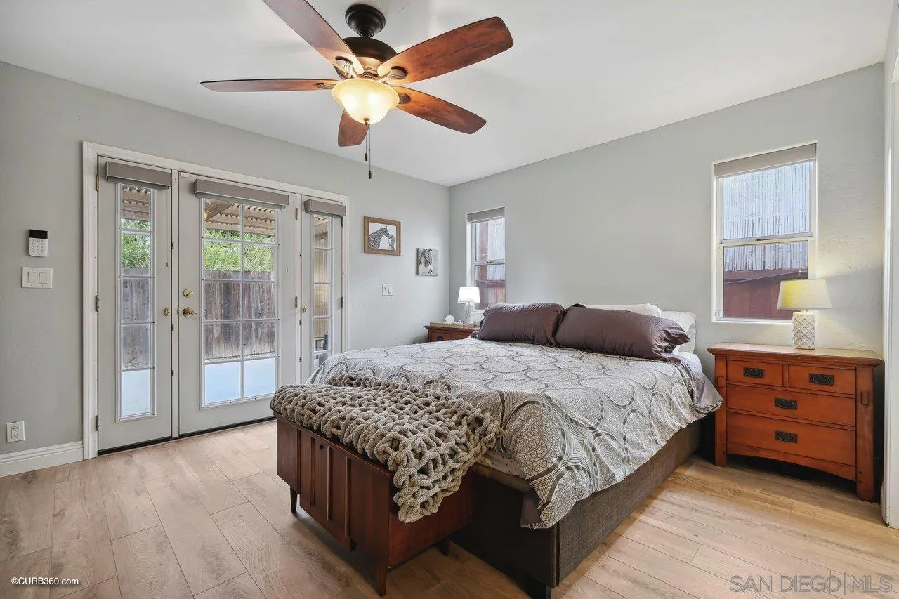 9541 Mandeville Road Santee, CA 92071 - Photo 21 of 32 a bedroom with a large bed and a chandelier