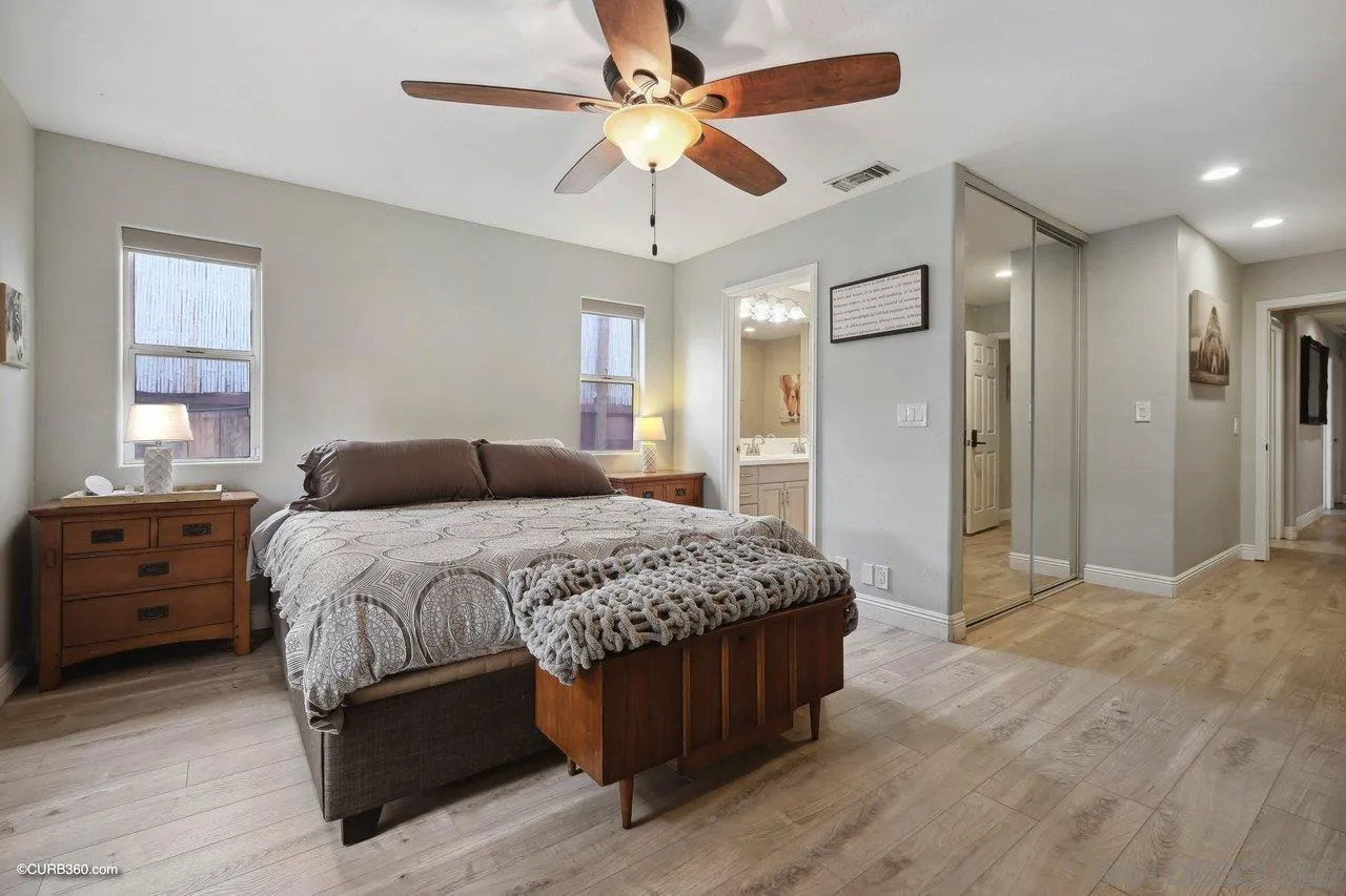 9541 Mandeville Road Santee, CA 92071 - Photo 22 of 32 a bedroom with a large bed a chandelier and closet