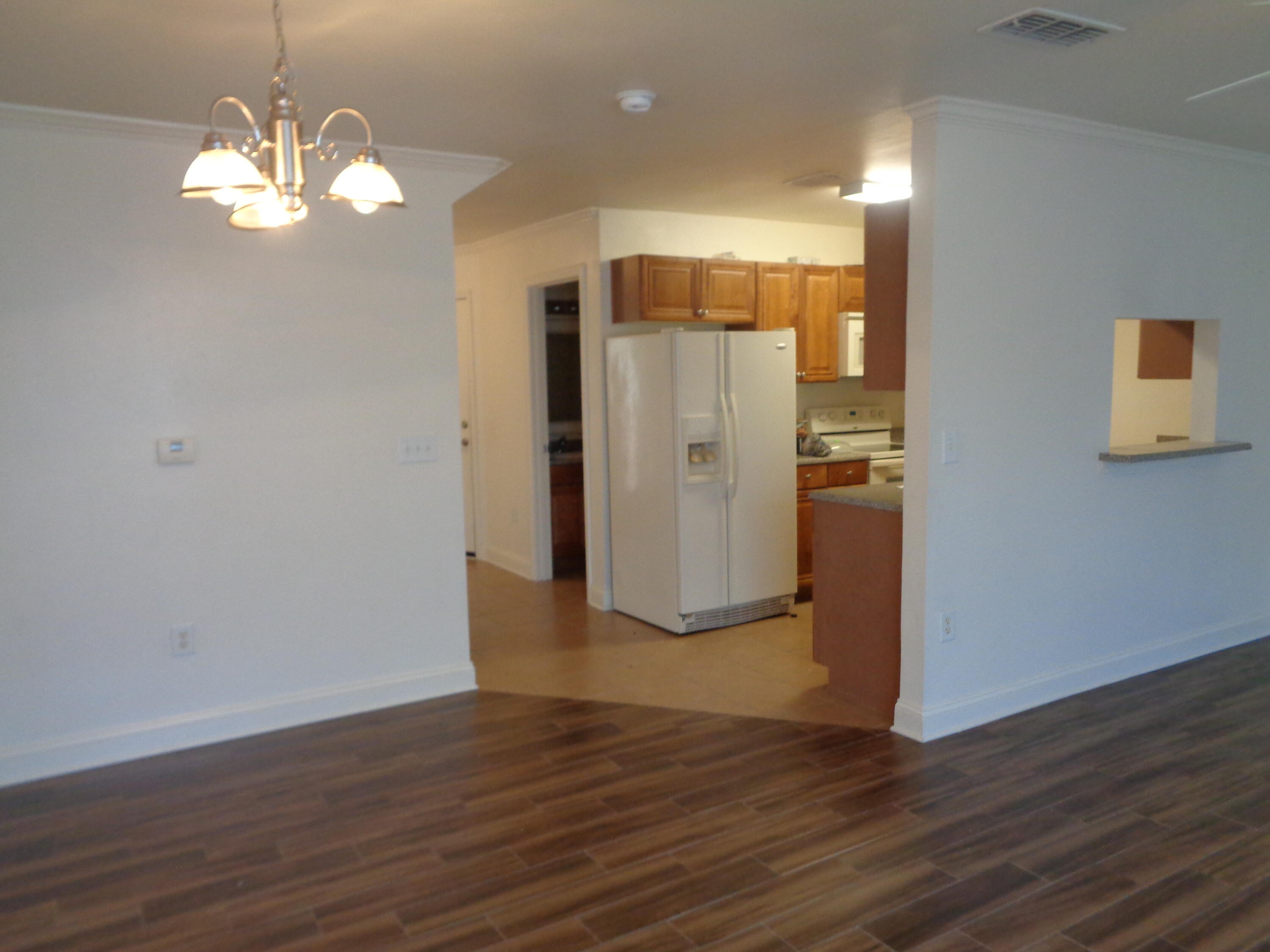 555 Wingspan Way Crestview, FL 32536 - Photo 6 of 24 a view of a room with wooden floor and chandelier