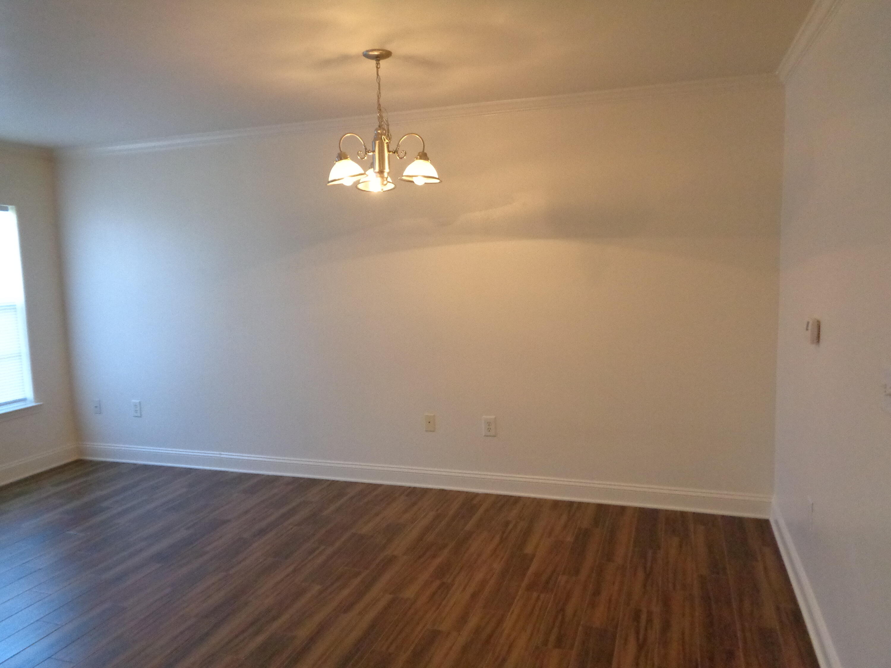 555 Wingspan Way Crestview, FL 32536 - Photo 7 of 24 a view of a room with wooden floor chandelier and window