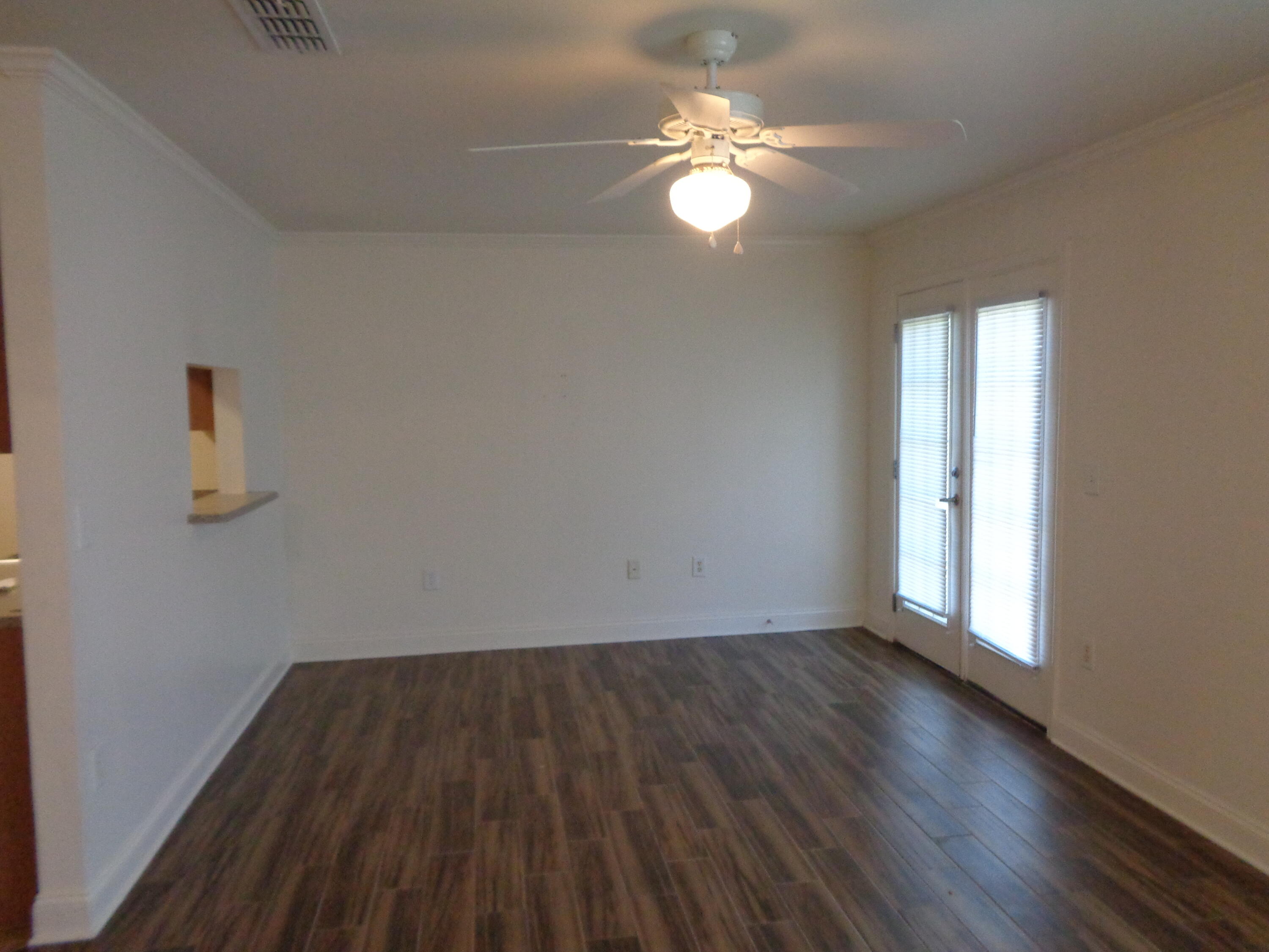 555 Wingspan Way Crestview, FL 32536 - Photo 8 of 24 an empty room with wooden floor and windows