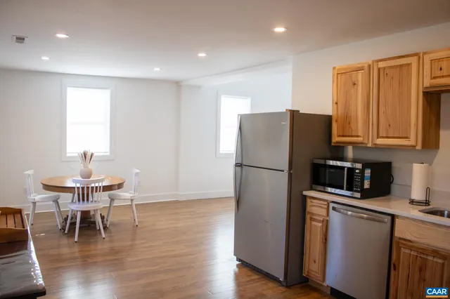 a kitchen with a refrigerator a table and chairs