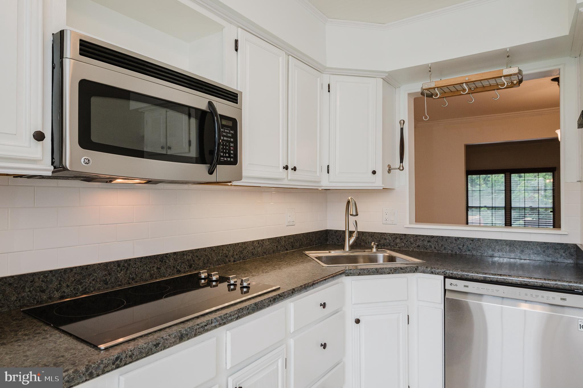 27 Faraday Drive Lutherville-Timonium, MD 21093 - Photo 13 of 60 a kitchen with granite countertop white cabinets and black stove top oven