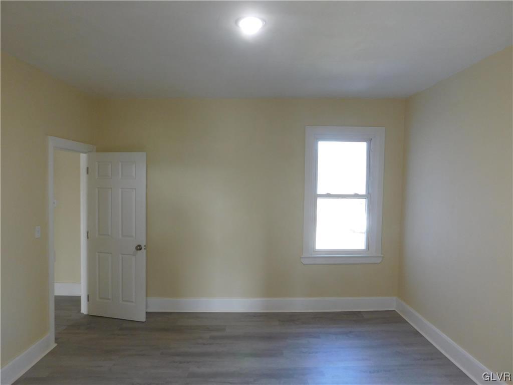121 Main Street Stockertown, PA 18083 - Photo 18 of 28 an empty room with wooden floor and windows