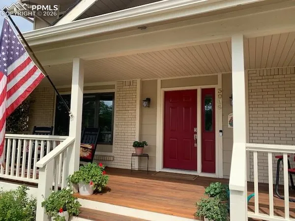 a view of a balcony with chairs and wooden floor
