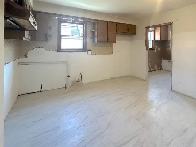 a view of a hallway with wooden floor and a bathroom
