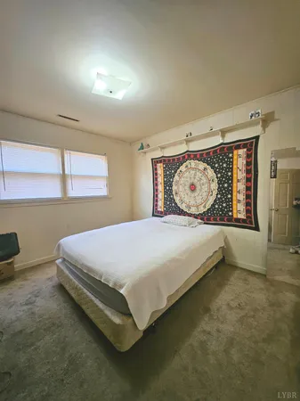 a bed sitting in a bedroom next to a window