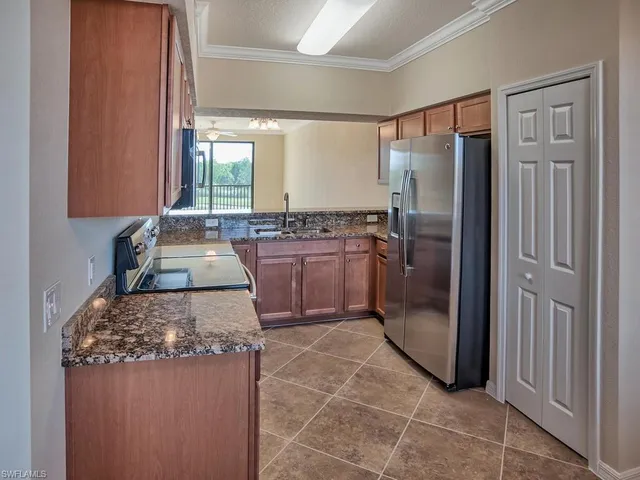 a kitchen with stainless steel appliances granite countertop a refrigerator and a stove