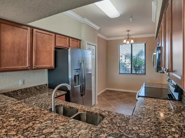 a kitchen with stainless steel appliances granite countertop a refrigerator sink and stove