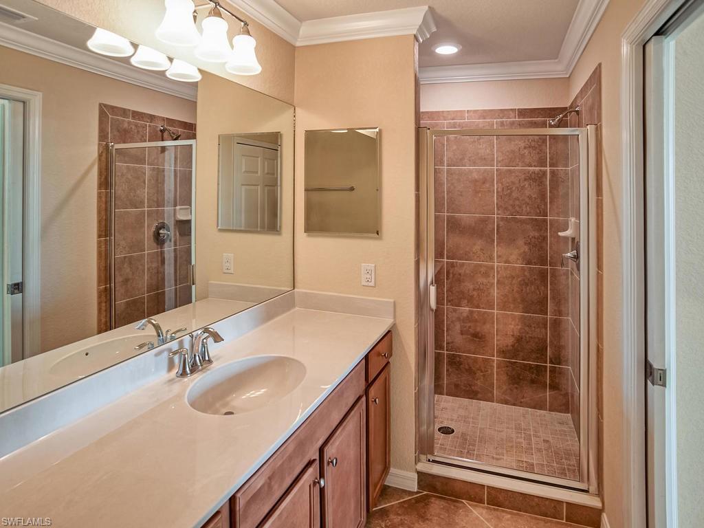 9566 Trevi Court, Unit 4934 Naples, FL 34113 - Photo 9 of 27 a bathroom with a shower sink and mirror