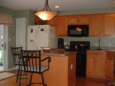 4145 Walter Road Bethlehem, PA 18020 - Photo 5 of 11 a kitchen with stainless steel appliances granite countertop a stove top oven a sink a dining table and chairs with wooden floor