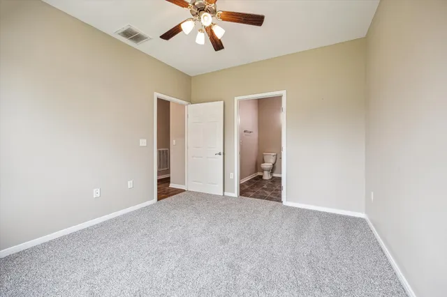 a view of an empty room with a chandelier fan