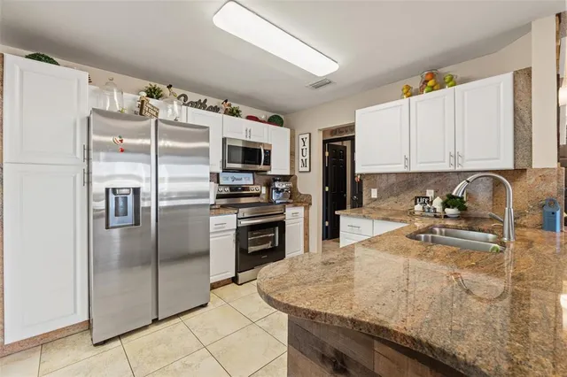 a kitchen with kitchen island a counter top space cabinets stainless steel appliances and a counter space
