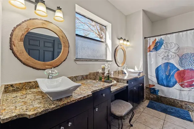 a bathroom with a granite countertop sink and a mirror