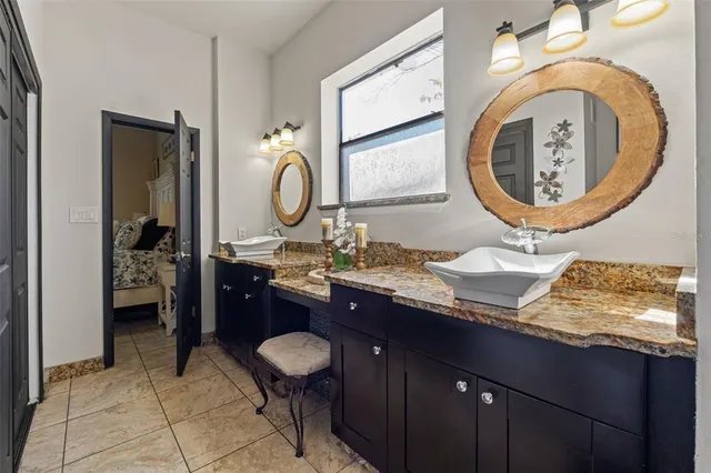 a bathroom with a granite countertop sink a toilet and a mirror