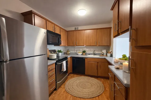 a kitchen with stainless steel appliances granite countertop a refrigerator a stove a sink and a microwave