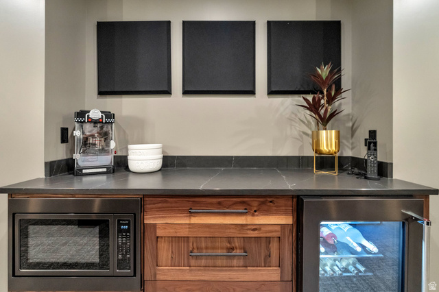 2145 North Main Street Centerville, UT 84014 - Photo 50 of 53 Bar with beverage cooler, stainless steel microwave, dark stone counters, and wood finish cabinetry