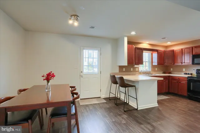 a kitchen with a dining table chairs and wooden floor