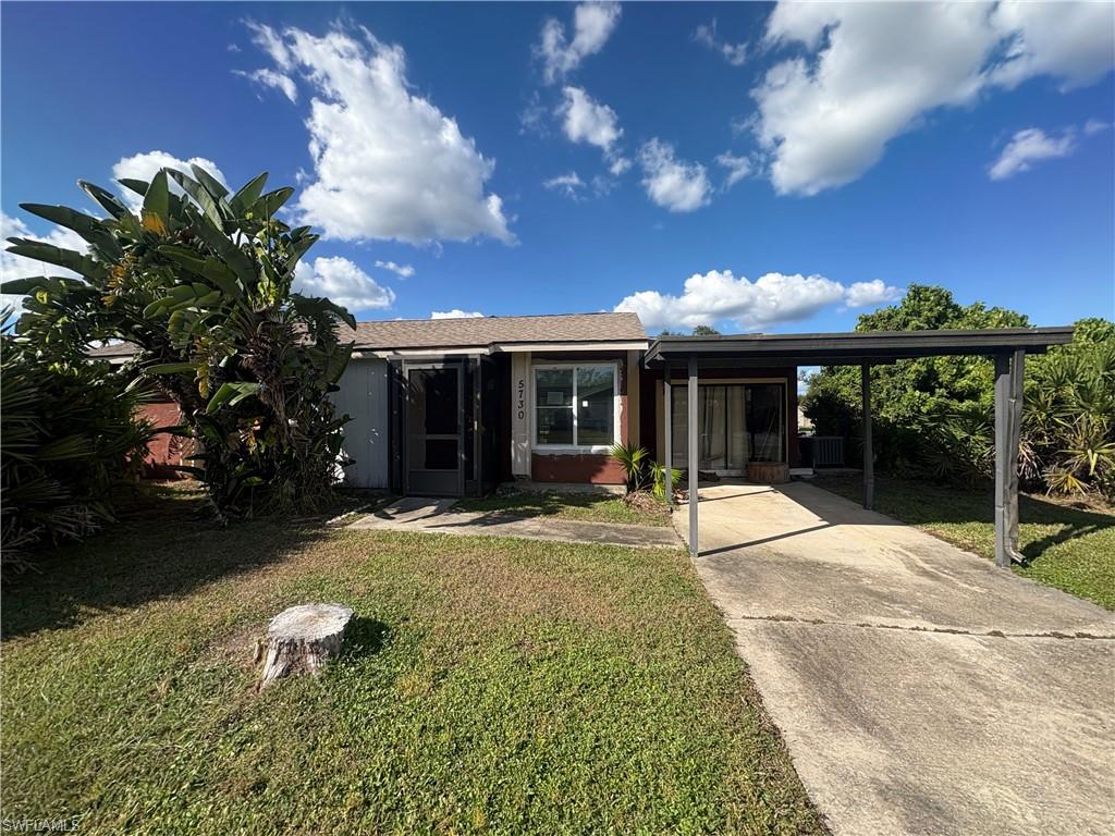 5730 Talbrook Road North Port, FL 34287 - Photo 2 of 2 View of front facade with a front lawn, a carport, and concrete driveway