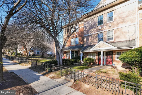 a view of a building with sitting area and large trees
