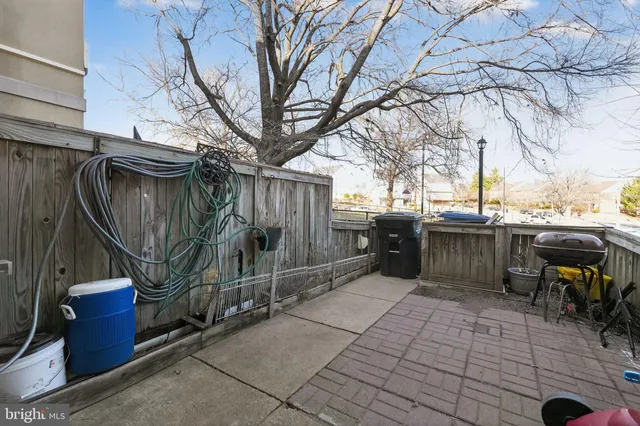 a view of a patio with table and chairs with wooden fence and plants