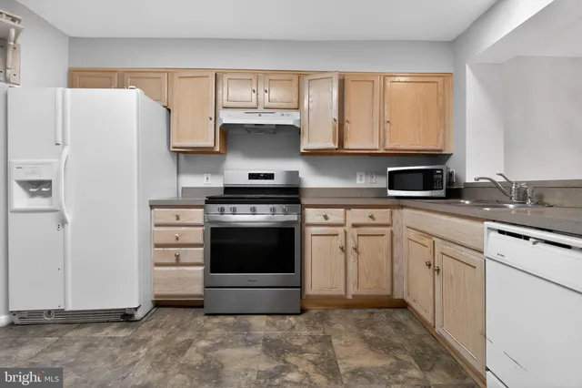 a kitchen with stainless steel appliances a stove a refrigerator and a sink