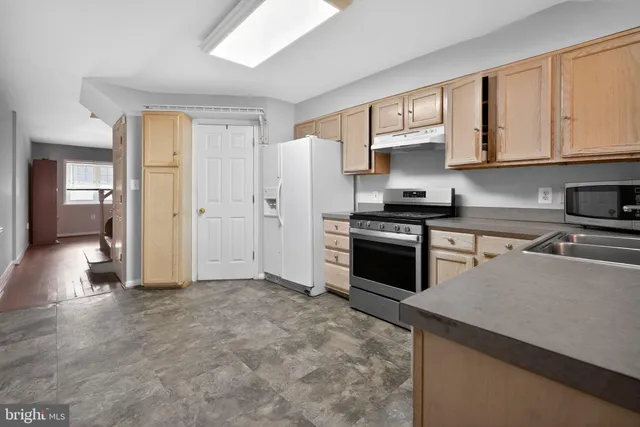 a kitchen with stainless steel appliances a stove sink and refrigerator