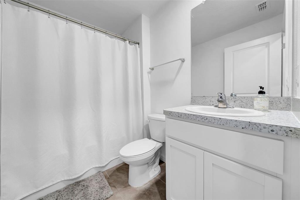 13295 Mylion Way, Unit 1 Spring Hill, FL 34610 - Photo 19 of 59 a bathroom with a granite countertop sink toilet and a mirror