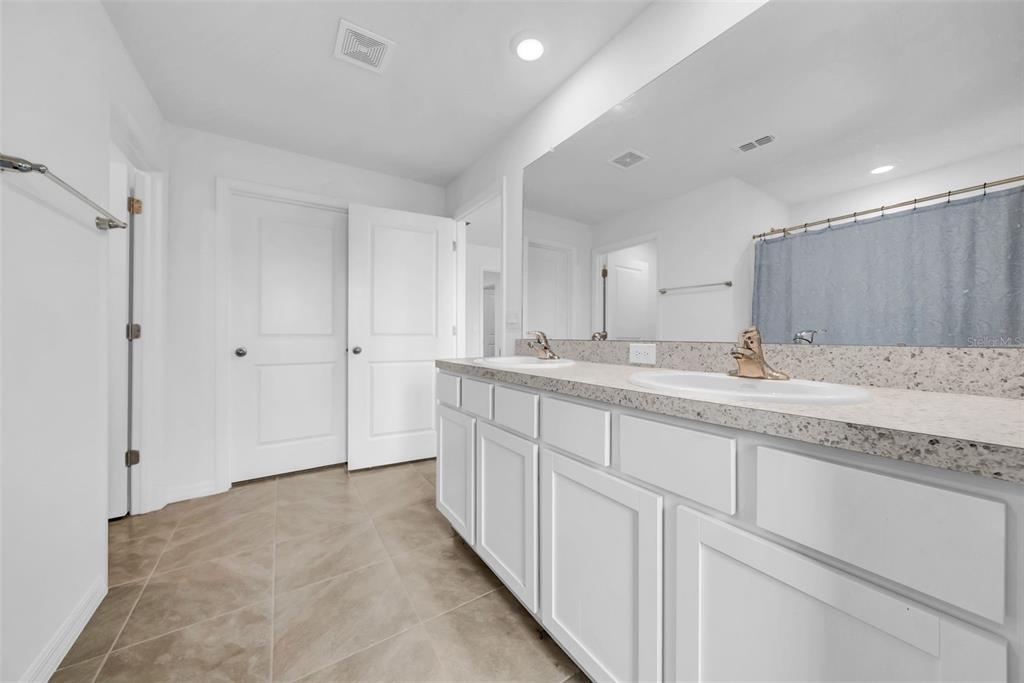 13295 Mylion Way, Unit 1 Spring Hill, FL 34610 - Photo 29 of 59 a spacious bathroom with a granite countertop sink mirror and cabinets