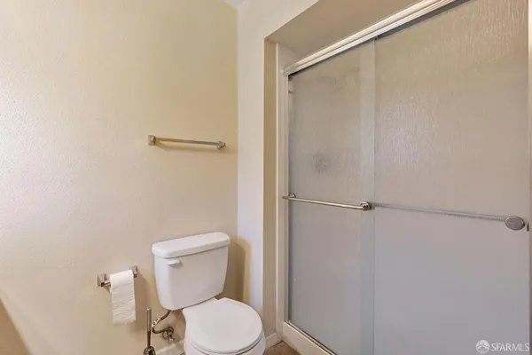a white toilet sitting next to a shower