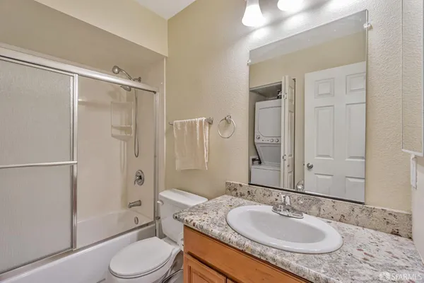 a bathroom with a granite countertop sink toilet a mirror and shower