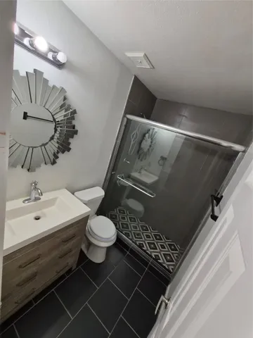 a bathroom with a sink a toilet and shower
