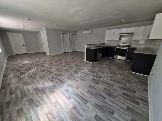 a large kitchen with kitchen island white cabinets and stainless steel appliances